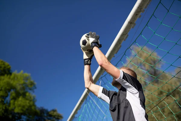 Målvakt med boll på fotbollsmål på fältet — Stockfoto