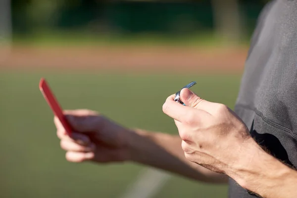 Mani dell'arbitro con cartellino rosso sul campo di calcio — Foto Stock