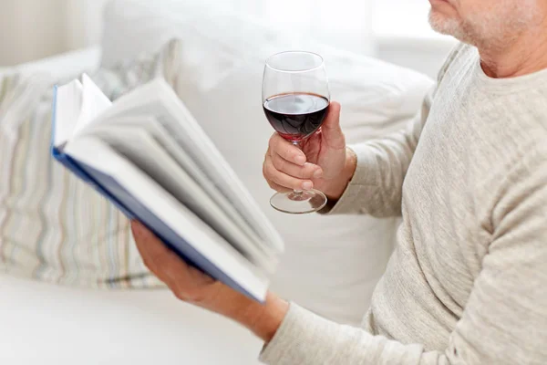 Κοντινό πλάνο του ανώτερος άνθρωπος με κρασί, διαβάζοντας το βιβλίο — Φωτογραφία Αρχείου