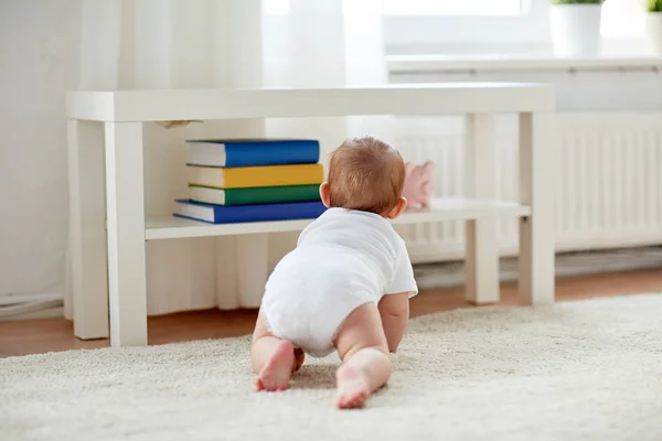 Малыш в подгузнике ползает по полу дома — стоковое фото