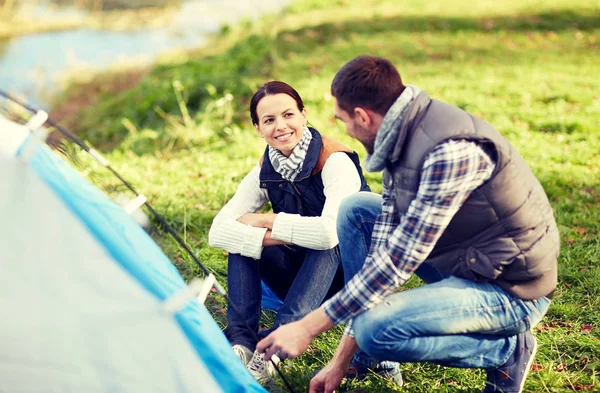 Happy couple setting up tent outdoors — Stock Photo, Image