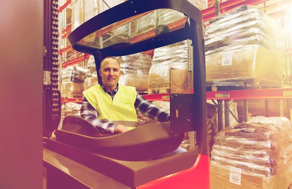 Sonriente hombre operando carretilla elevadora en el almacén — Foto de Stock