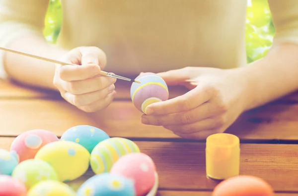 Close up of woman hands coloring easter eggs — Stock Photo, Image