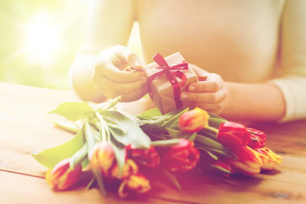 Κοντινό πλάνο της γυναίκας με δώρο κουτί και τουλίπα λουλούδια — Φωτογραφία Αρχείου