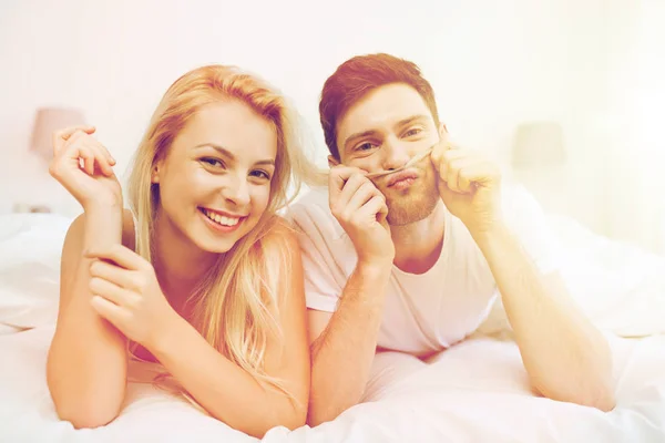 Happy couple lying in bed at home — Stock Photo, Image