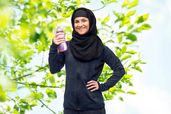 Donna musulmana con bottiglia d'acqua fare sport — Foto Stock