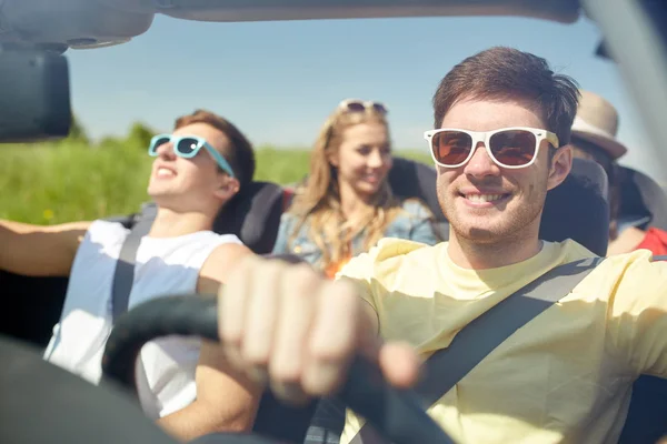 Amigos felizes dirigindo em carro cabriolet — Fotografia de Stock