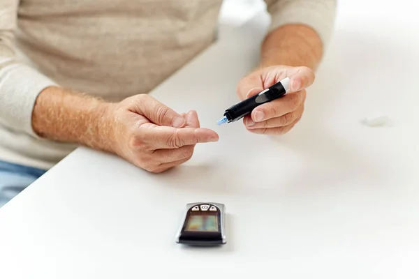 Senior man with glucometer checking blood sugar — Stock Photo, Image