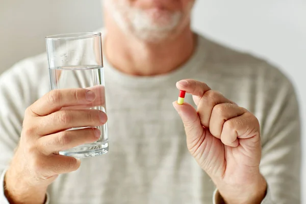 Close up of hands with medicine pills and water — Stock Photo, Image