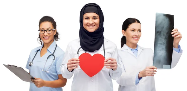 Médicos felices con corazón rojo, rayos X y portapapeles Imagen de stock