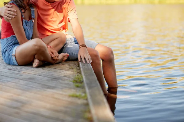 Feliz pareja adolescente sentada en la litera del río —  Fotos de Stock