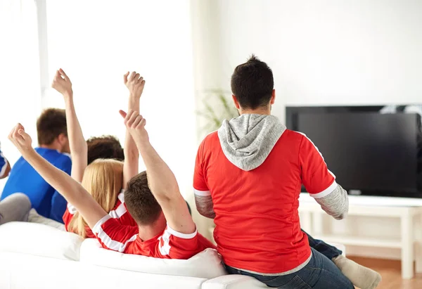 Друзья или футбольные болельщики смотрят телевизор дома — стоковое фото