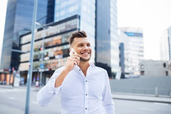 Счастливый мужчина со смартфоном звонит по городской улице — стоковое фото