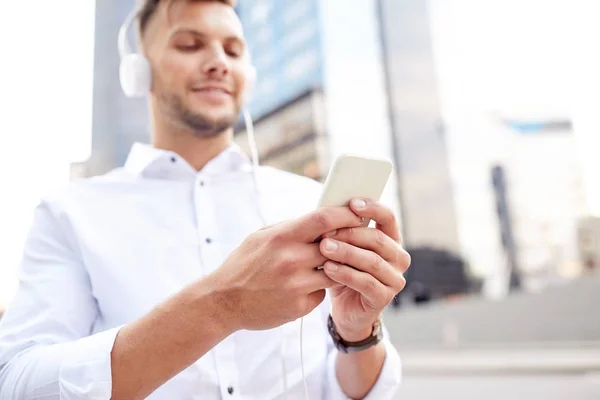 Adam akıllı telefon ve kulaklık müzik dinleme — Stok fotoğraf