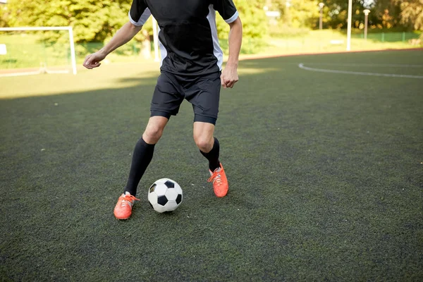 Voetbalspeler met bal op voetbalveld spelen — Stockfoto