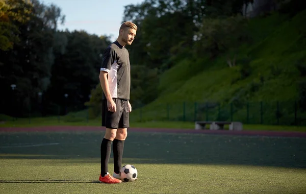 Fotbollspelare som leker med bollen på fotbollsplan — Stockfoto