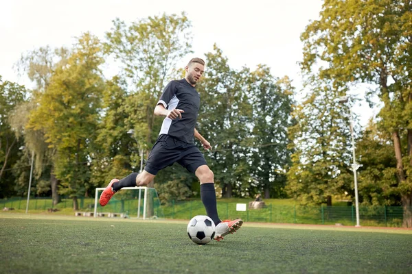 Jugador de fútbol jugando con pelota en el campo de fútbol — Foto de Stock