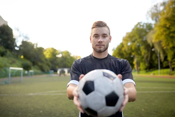 Voetbalspeler met bal op voetbalveld — Stockfoto