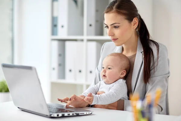 Donna d'affari felice con bambino e computer portatile in ufficio — Foto Stock