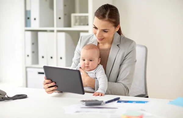 Zakenvrouw met baby en tablet pc op kantoor — Stockfoto