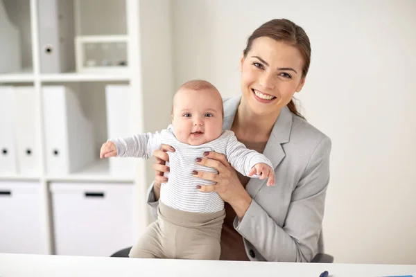 Glad affärskvinna med baby på kontor — Stockfoto