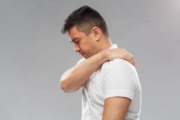 Несчастный человек страдает от боли в плече — стоковое фото