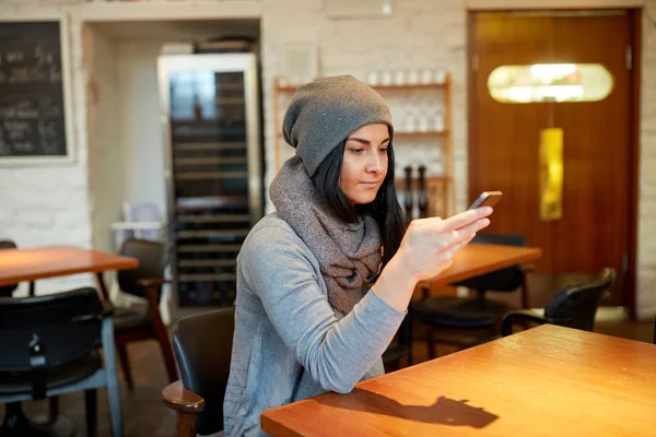 Młoda kobieta z smartphone w kawiarni — Zdjęcie stockowe