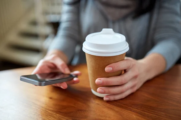 Närbild på kvinna med smartphone och kaffe — Stockfoto
