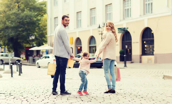 Lycklig familj med barn och shopping påsar i city — Stockfoto