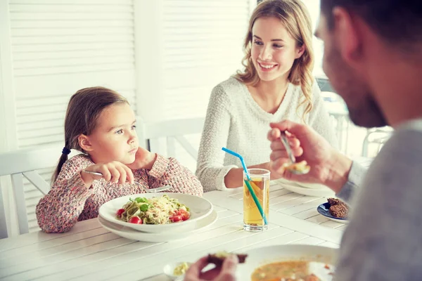 Счастливая семья ужинает в ресторане или кафе — стоковое фото