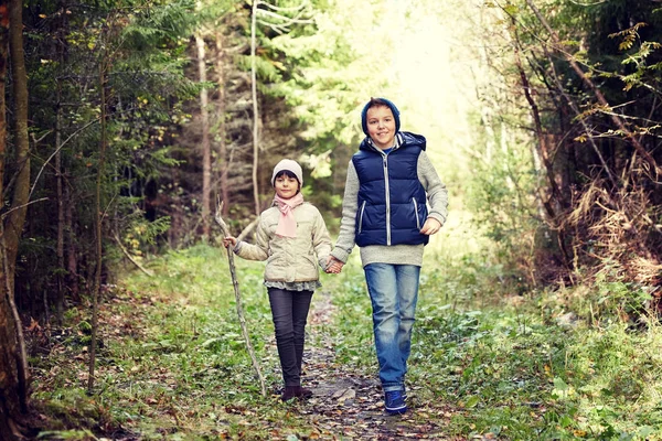 Два счастливых ребенка идут по лесной тропе — стоковое фото