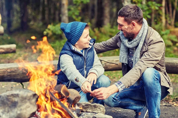 Pai e filho assar marshmallow sobre fogueira — Fotografia de Stock