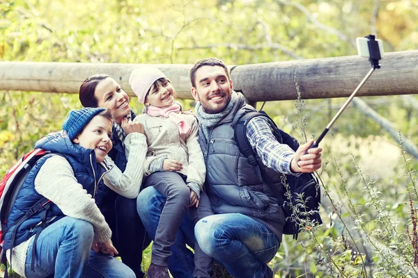 Lycklig familj med smartphone selfie pinne i skogen — Stockfoto