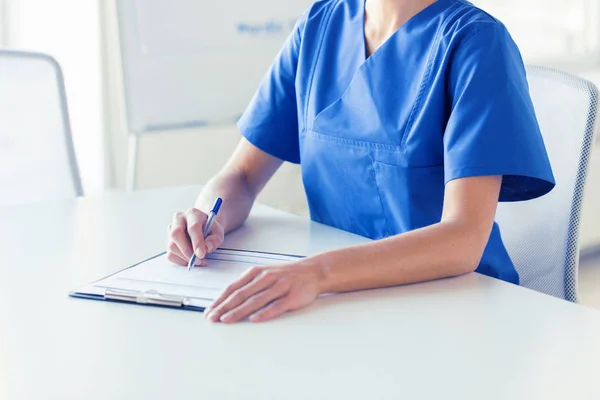 Primer plano de la escritura del médico o la enfermera al portapapeles — Foto de Stock