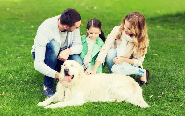 Happy family with labrador retriever dog in park — Stock Photo, Image