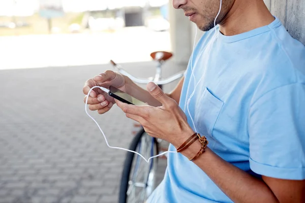 Homem com fones de ouvido e smartphone ouvindo música — Fotografia de Stock