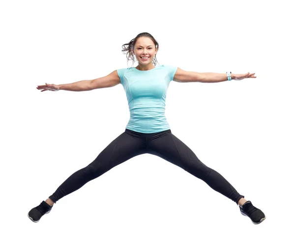 Glad leende sportig ung kvinna hoppar i luften — Stockfoto