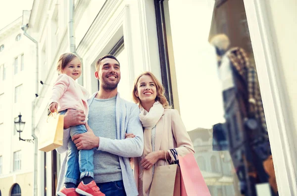 Boldog család, gyermek, és a város bevásárló táskák — Stock Fotó