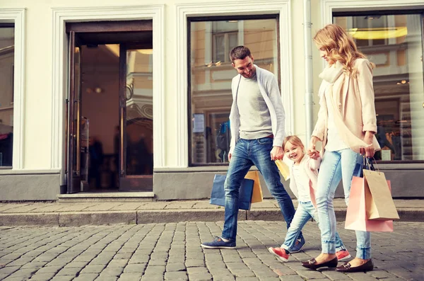 Famiglia felice con bambino e shopping bag in città — Foto Stock