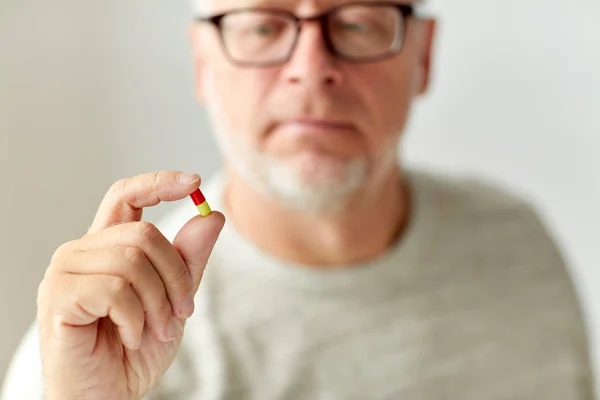 Close up of senior man with medicine pill — Stock Photo, Image