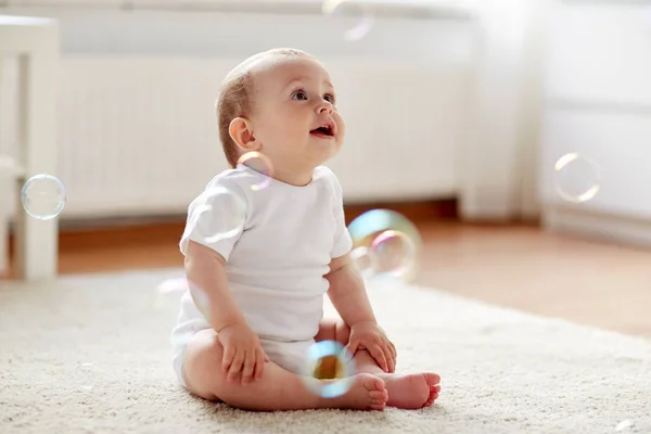 Bebé feliz con burbujas de jabón en casa — Foto de Stock