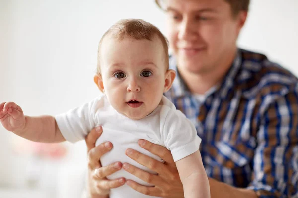 Feliz jovem pai com pequeno bebê em casa — Fotografia de Stock