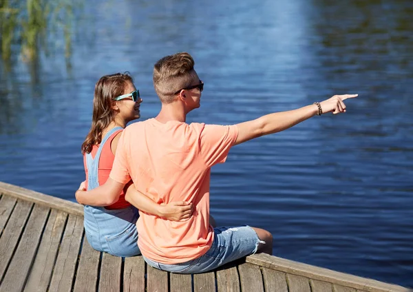 Szczęśliwa para palcem wskazującym na nabrzeżu rzeki lato — Zdjęcie stockowe