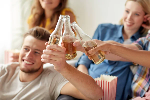 Amis heureux cliquetis bouteilles de bière à la maison fête — Photo