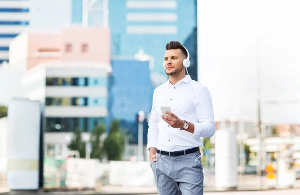 Mann mit Kopfhörer und Smartphone hört Musik — Stockfoto