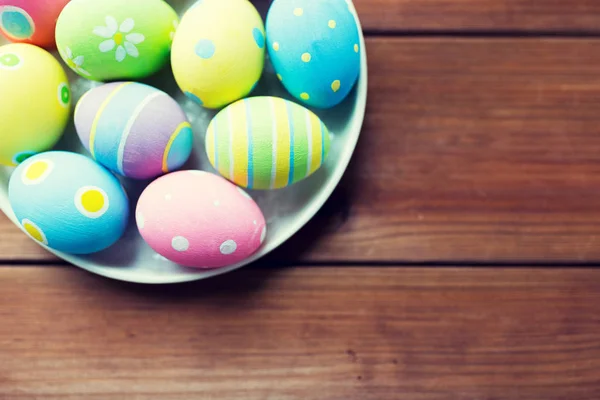 Perto de ovos de páscoa coloridos na placa — Fotografia de Stock
