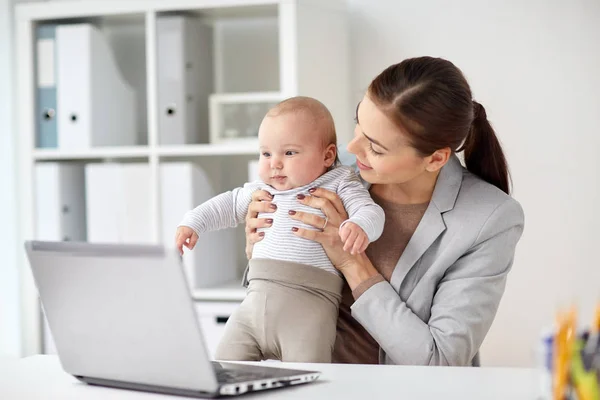 Glad affärskvinna med baby och laptop på kontoret — Stockfoto