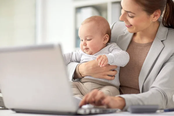 Glückliche Geschäftsfrau mit Baby und Laptop im Büro — Stockfoto