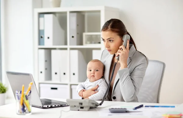 Empresária com bebê chamando no telefone no escritório — Fotografia de Stock