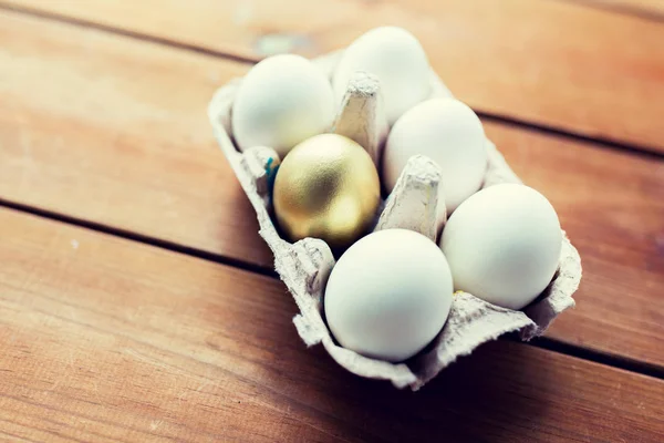 Primo piano di uova bianche e d'oro in scatola di uova — Foto Stock